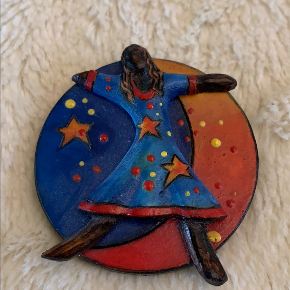 Wooden brooch with stars, moon, and woman.